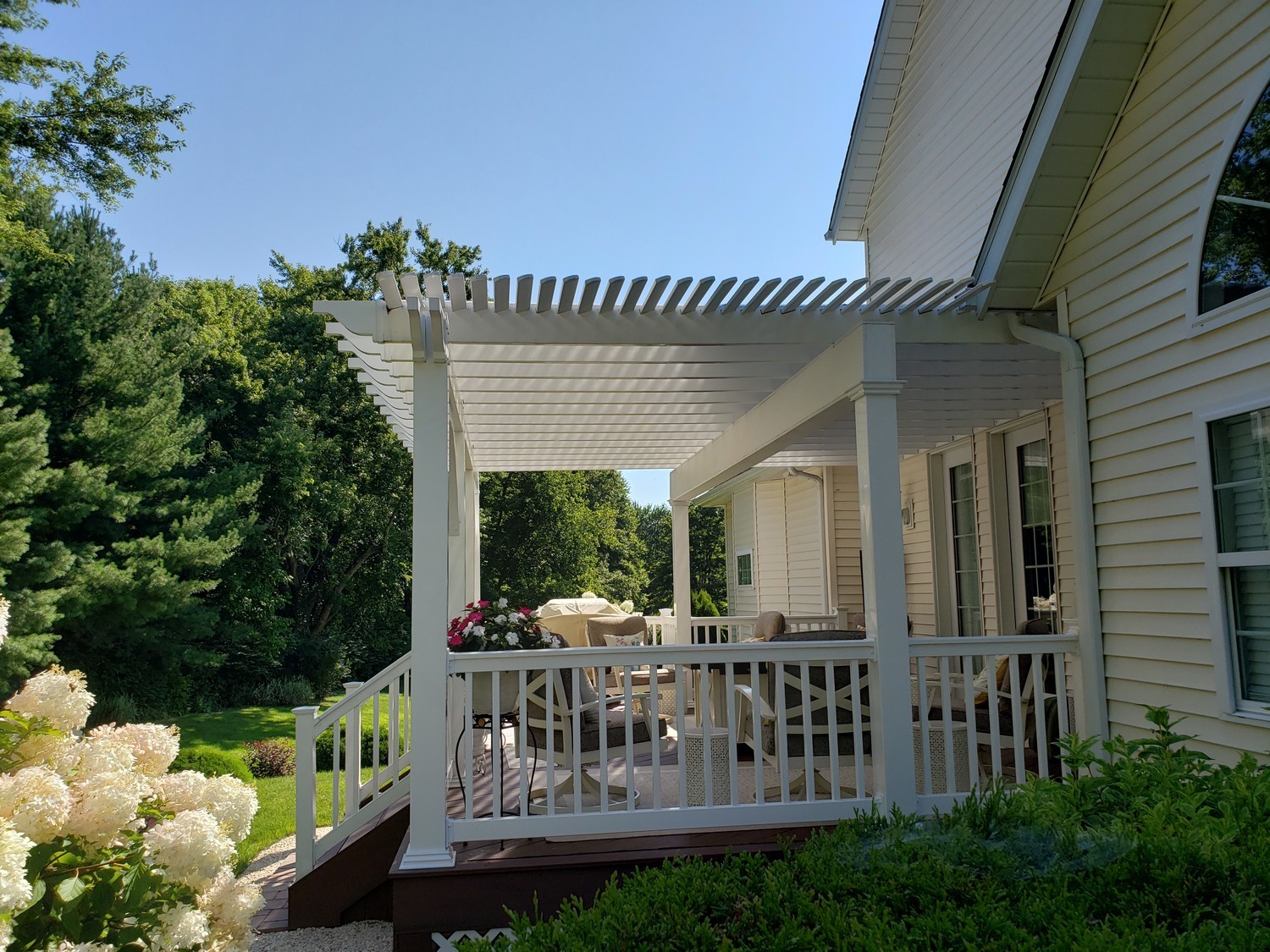 white pergola on the back of a home